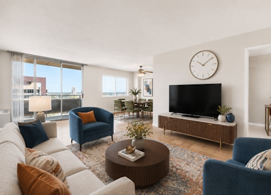 A living room with a large flat screen TV on a wooden stand.