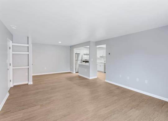 a living room with a hard wood floor and a kitchen