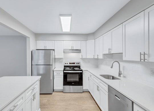 a large white kitchen with white cabinets and stainless steel appliances