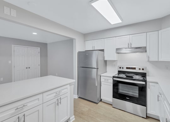 a renovated kitchen with white cabinets and stainless steel appliances