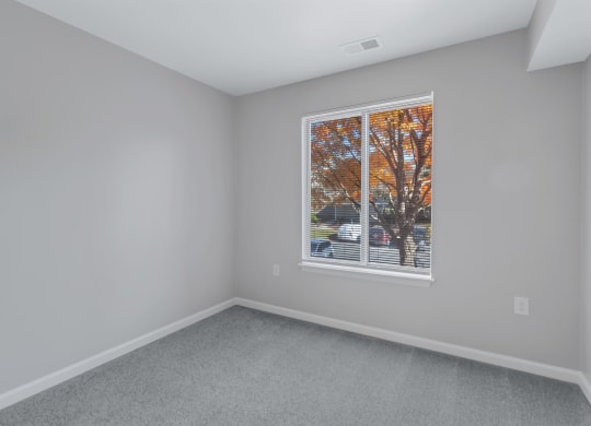 an empty room with a large window in the center of it