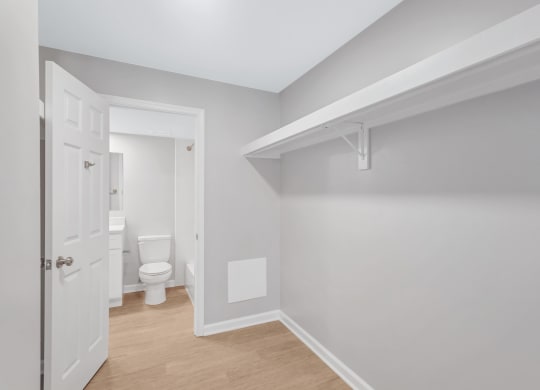an empty room with a toilet and a hallway to a bathroom