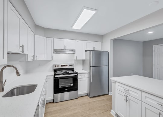 a large kitchen with white cabinets and stainless steel appliances