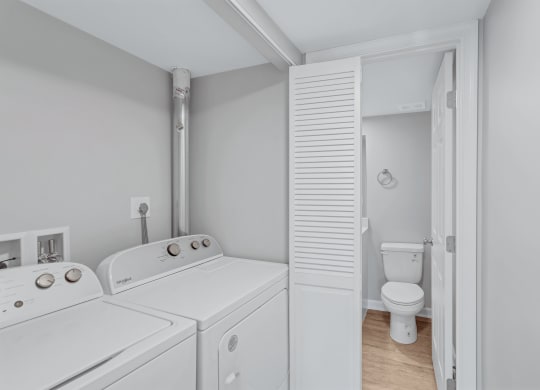 a washer and dryer in a laundry room next to a toilet