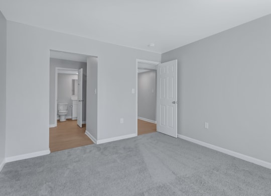 a living room with a carpet and a door to a bathroom