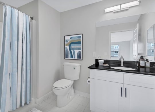 a bathroom with a toilet and a sink and a shower