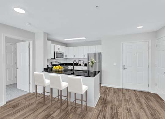 a kitchen with white cabinets and a black counter top