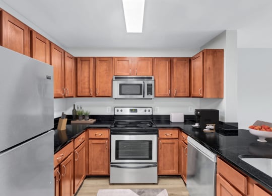 a kitchen with wooden cabinets and stainless steel appliances