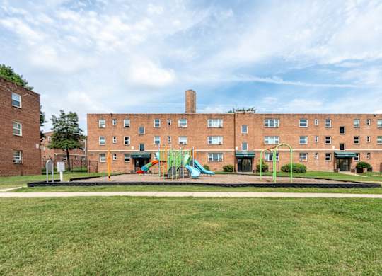 A large brick building with a playground in front.
