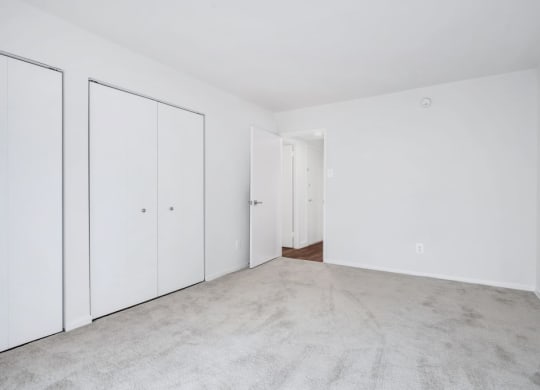 an empty bedroom with white walls and white doors