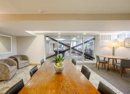 A conference room with a long wooden table and chairs.