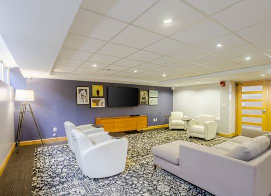A living room with a grey sofa, a white chair and a white couch.