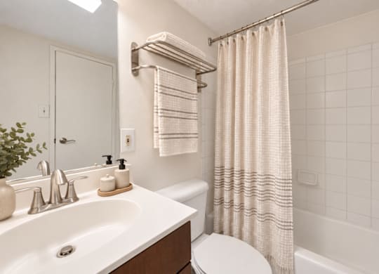 A white bathroom with a toilet, sink, and bathtub.