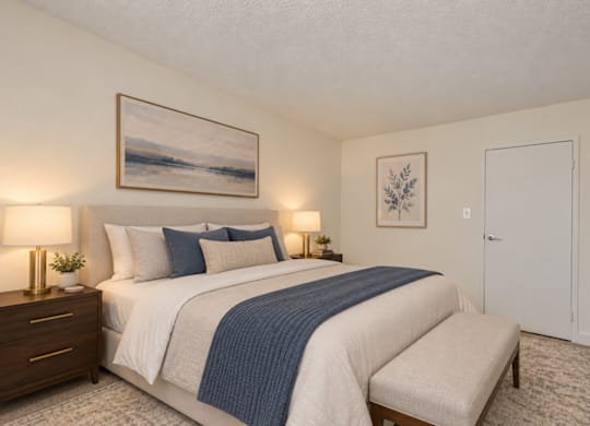 A bedroom with a large bed and a painting on the wall.