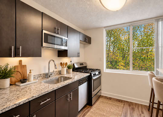 A kitchen with a sink, stove, and microwave.