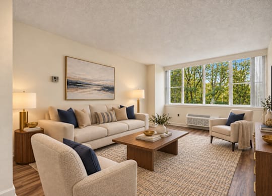 A living room with a large painting on the wall and a couch with blue pillows.