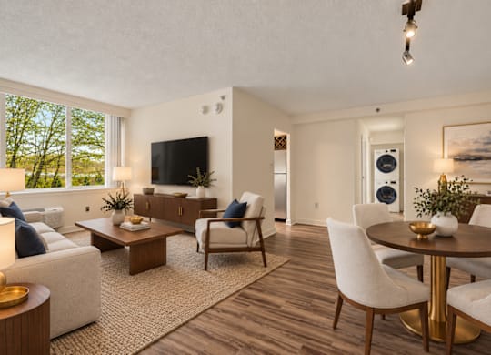 A living room with a white couch, a coffee table, and a television.
