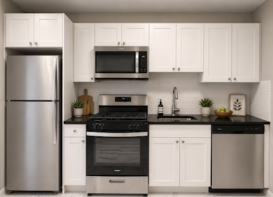 A modern kitchen with a stainless steel refrigerator, black countertops, and white cabinets.