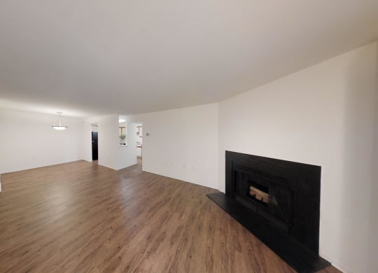 a living room with a black fireplace and wooden floors