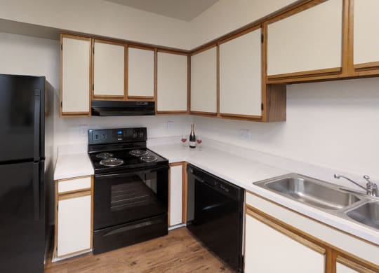 an empty kitchen with black appliances and white cabinets