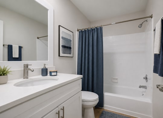 A bathroom with a white sink and a white toilet.