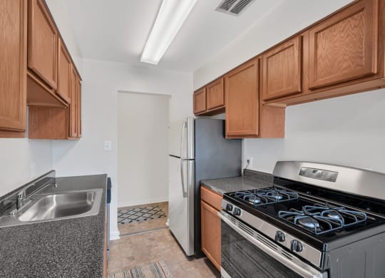 a kitchen with wood cabinets and stainless steel appliances