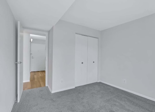 an empty bedroom with white walls and wood floors