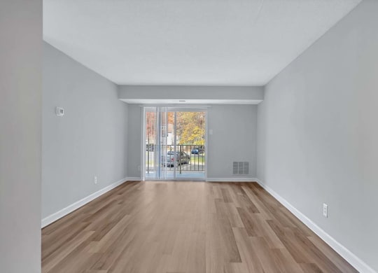 the living room is spacious and has a sliding glass door to the balcony