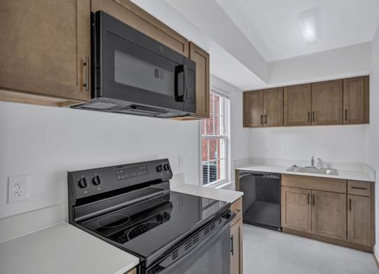 A modern kitchen with a black microwave above the stove.