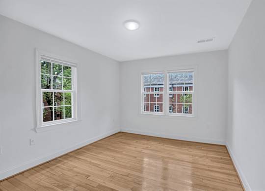 A room with a window and a wooden floor.