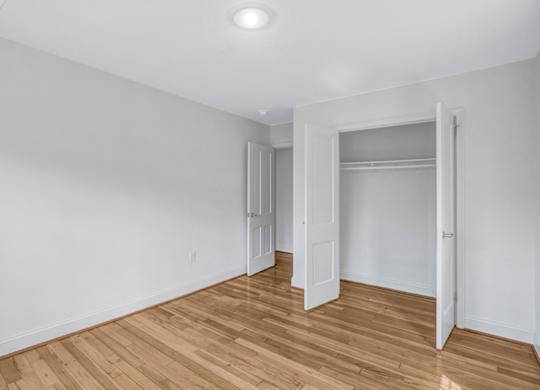 A room with wooden flooring and white walls.