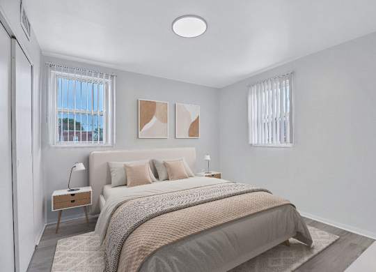 A bedroom with a large bed and a window with blinds.