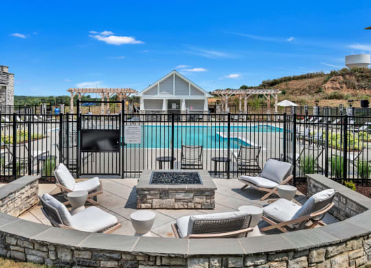 an outdoor patio with chairs and a fire pit and a swimming pool