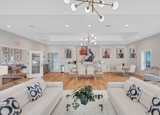 a clubroom with white sofas, a dinette, and are on the walls.