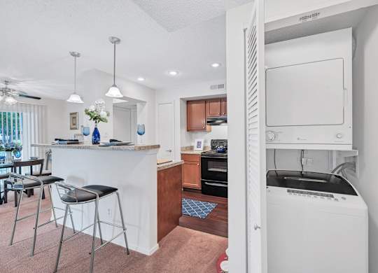 a white kitchen with a bar and a dining room
