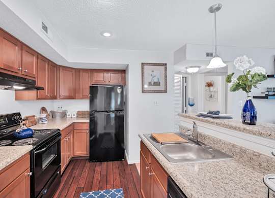 a kitchen with granite counter tops and a black refrigerator