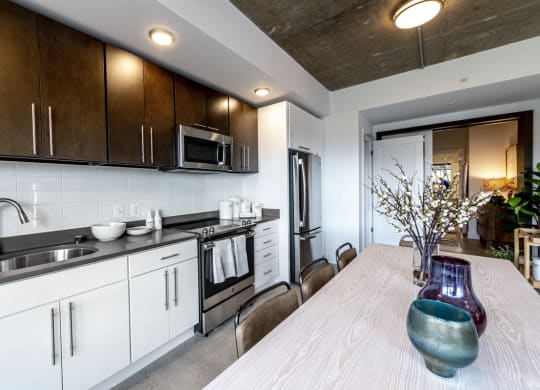 Kitchen and dining area with table and chairs.