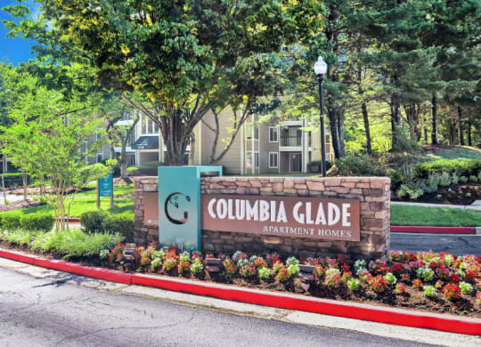 a sign for the columbia glade amusement park in front of a garden