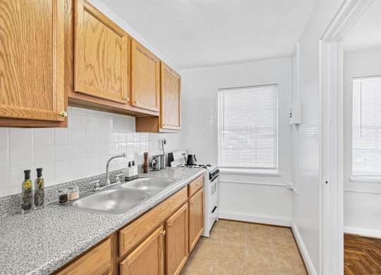 A kitchen with wooden cabinets and a granite countertop.