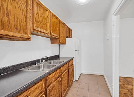 A kitchen with wooden cabinets and a white refrigerator.