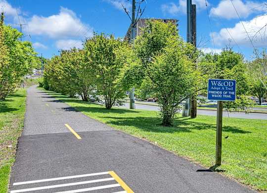 A blue sign on a sidewalk that says