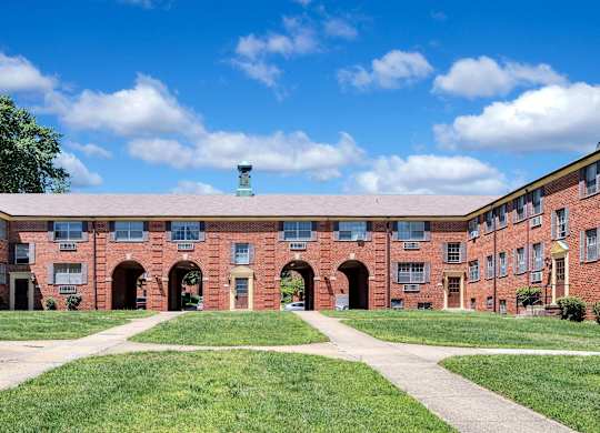 A red brick building with a green roof and a clear blue sky above.