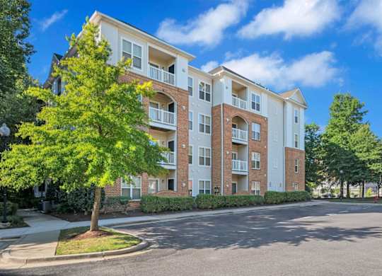 A large apartment building with a tree in front of it.
