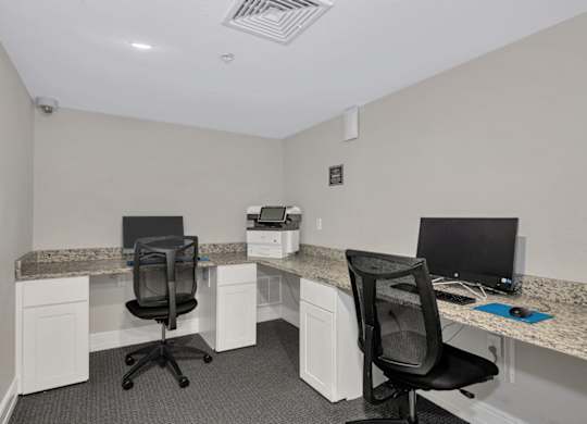 Two chairs and two desks in a small office.