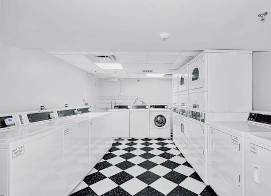 the kitchen has a checkered floor and white appliances