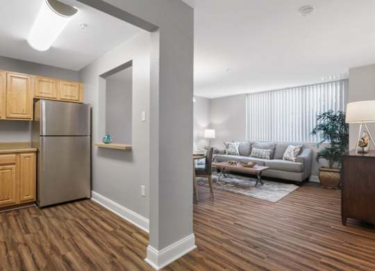 A kitchen with wooden cabinets and a stainless steel refrigerator.