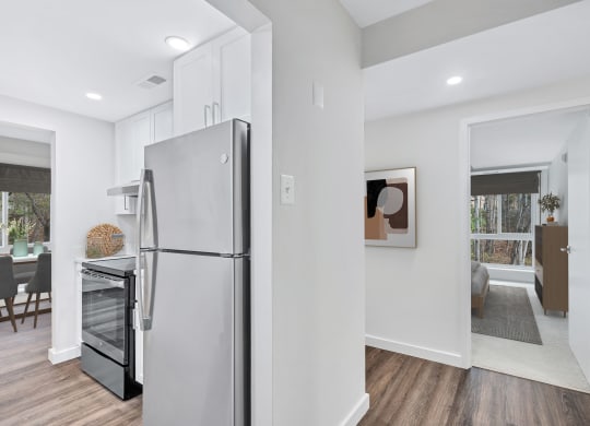 a renovated kitchen with white walls and a stainless steel refrigerator