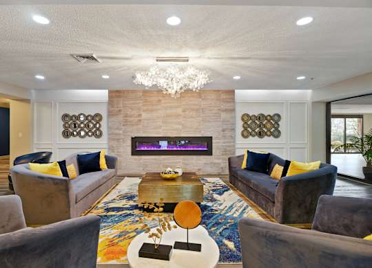 A modern living room with a grey sofa, a wooden coffee table, and a chandelier.