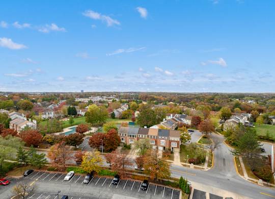 A view of a town with a parking lot in the foreground.