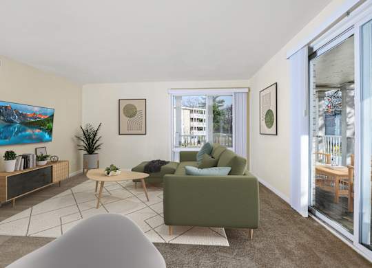 A living room with a green couch, a wooden table, and a painting on the wall.